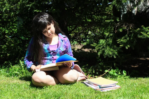 Молодая девушка делает домашнее задание на улице — стоковое фото