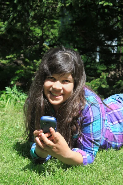 Νεαρή κοπέλα, χαμογελά με κινητό τηλέφωνο — Φωτογραφία Αρχείου