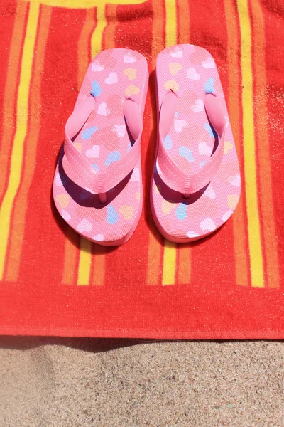 Sandalias en toalla de playa — Foto de Stock
