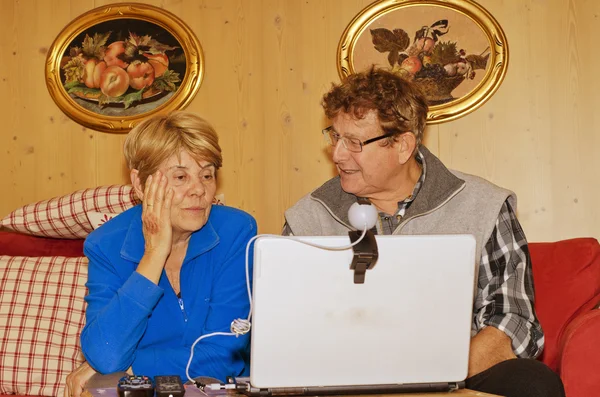 Äldre par med anteckningsboken för videosamtal — Stockfoto