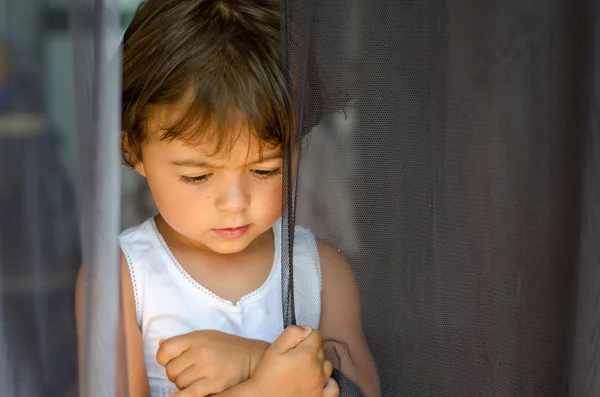 Baby wiith hennes tankar bakom gardinen, Italien — Stockfoto