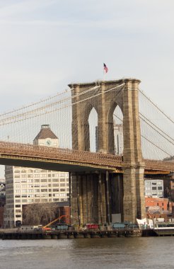 Portrait view of Brooklyn Bridge Tower and flag in New York City clipart