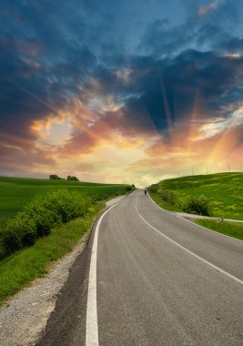 Countryside Road in Tuscany with Cloudy and Colorful Sky clipart