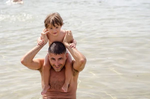 Kız çocuğu babası ile plajda oynamak için mutlu — Stok fotoğraf
