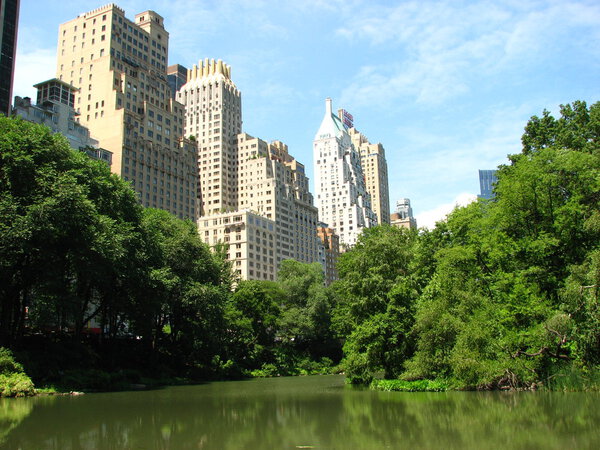 Skyscrapers of Manhattan from Central Park with Lake and Trees in foreground - New York City