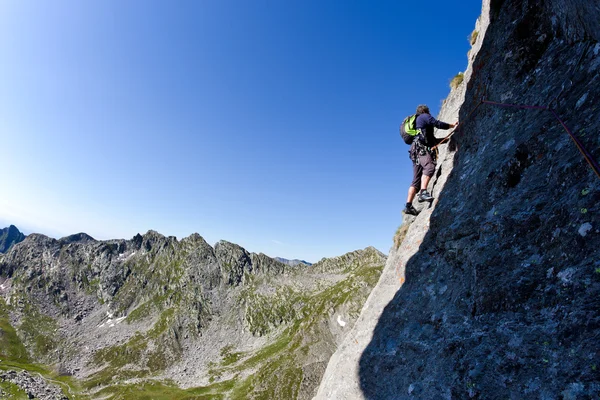 Kaukasischer männlicher Kletterer klettert eine steile Wand hinauf — Stockfoto