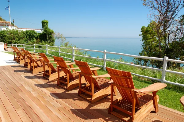 Zobrazit oblast moře s dřevěnými židlemi v moderní a luxusní hotel, koláč — Stock fotografie