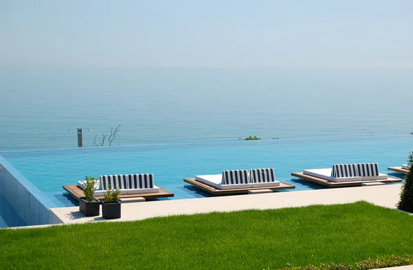 Sonsuzluk Yüzme Havuzu tarafından modern lüks otelin plajında pier — Stok fotoğraf