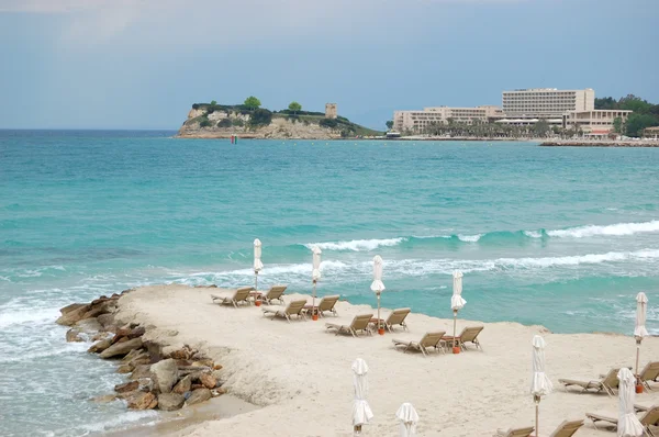 Lettini su una spiaggia e acqua turchese al moderno hote di lusso — Foto Stock