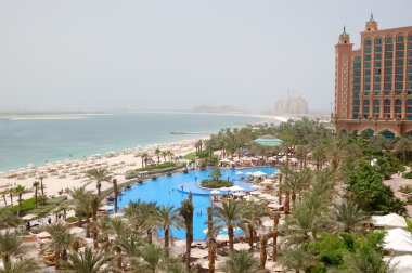 The beach and swimming pool at luxury hotel, Dubai, UAE clipart