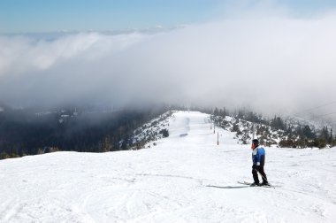 Skier rides on a slope in Strbske Pleso ski resort, High Tatras, clipart