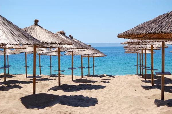 Sonnenschirme am Strand und türkisfarbenes Wasser im Luxushotel, — Stockfoto
