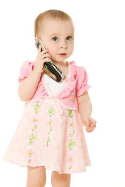 Κοριτσάκι, μιλώντας στο τηλέφωνο σε ένα ροζ φόρεμα — Φωτογραφία Αρχείου