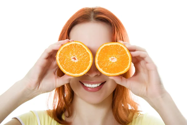 Забавный женский портрет, держащий апельсины над глазами — стоковое фото