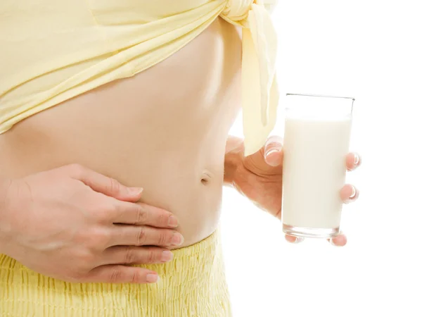 Kobieta trzyma szklankę mleka w żołądku — Zdjęcie stockowe