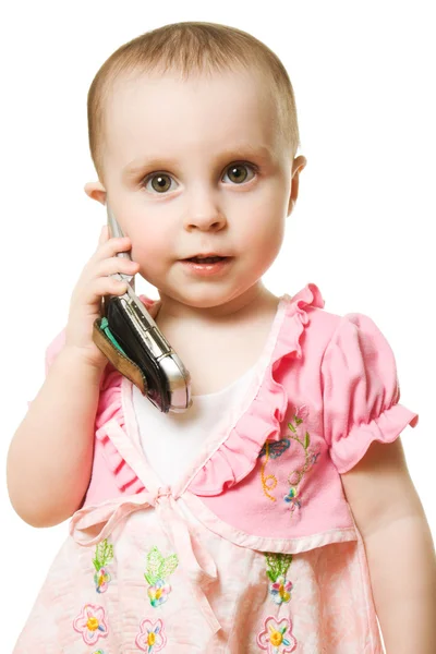Beszél a telefonon, egy rózsaszín ruhás kislány — Stock Fotó