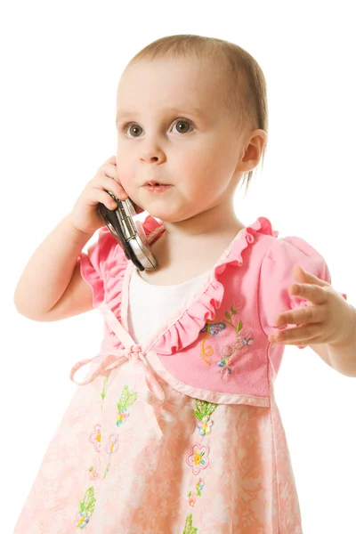 Klein meisje praten over de telefoon in een roze jurk — Stockfoto
