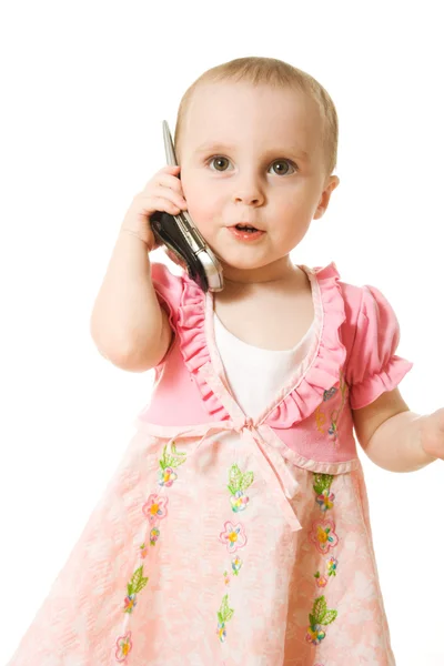 Küçük kız pembe elbise giymiş telefonda konuşurken — Stok fotoğraf
