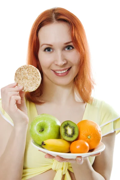 Mujer joven con fruta en un plato y panes — Foto de Stock