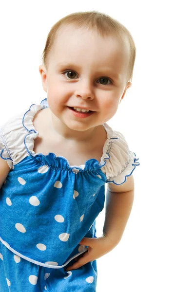 Liten flicka i blå klänning leende på vit bakgrund — Stockfoto