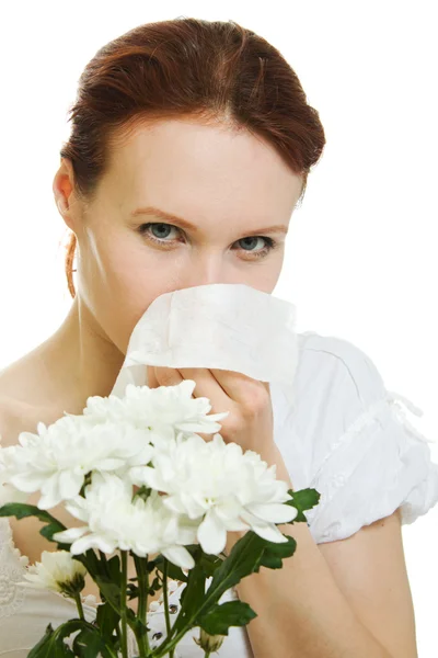 Jovem mulher com flores da primavera alergia espirros sobre fundo branco — Fotografia de Stock