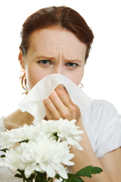 Девушка с аллергией на весенние цветы чихает на белом фоне — стоковое фото
