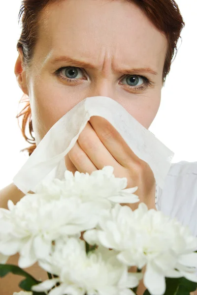 Jovem mulher com flores da primavera alergia espirros sobre fundo branco — Fotografia de Stock