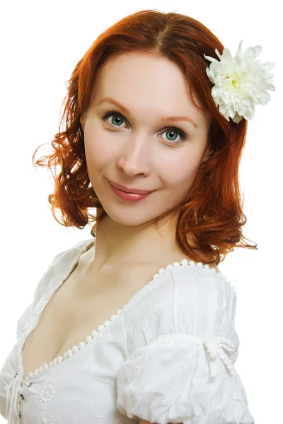 Gezonde huid van jonge mooie vrouw gezicht met een bloem in haar haren op een witte achtergrond. — Stockfoto