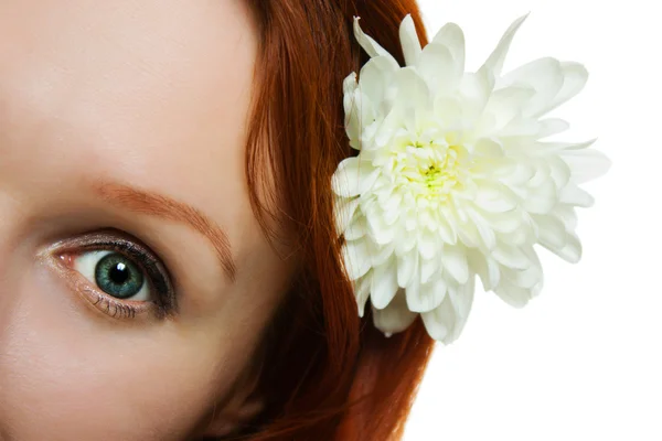 Gezonde huid van jonge mooie vrouw gezicht met een bloem in haar haren op een witte achtergrond. — Stockfoto