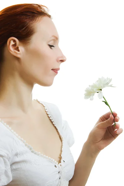 Flicka att lukta en blomma på en vit bakgrund. — Stockfoto