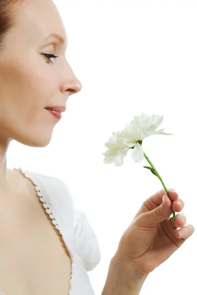 Chica oliendo una flor sobre un fondo blanco . —  Fotos de Stock