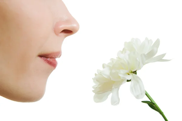 Mädchen, das eine Blume auf weißem Hintergrund riecht. — Stockfoto