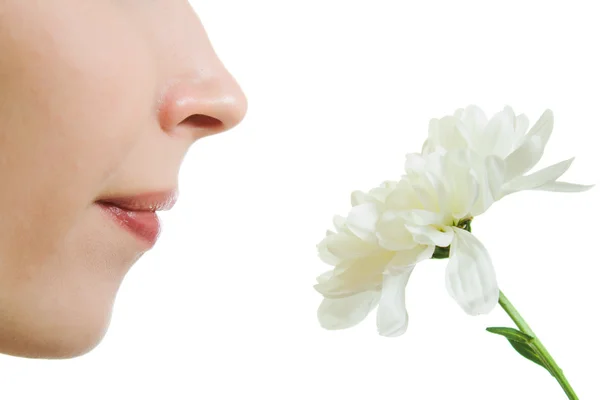 Meisje ruiken een bloem op een witte achtergrond. — Stockfoto