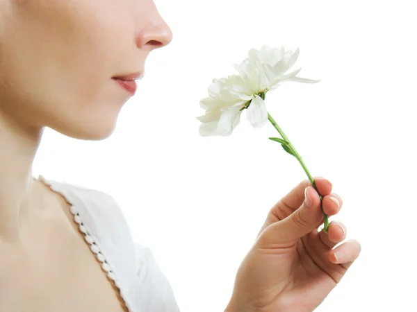 Chica oliendo una flor sobre un fondo blanco . —  Fotos de Stock