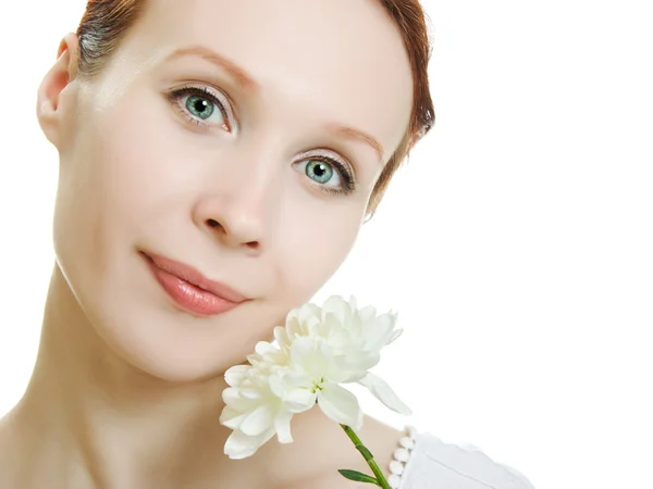 Une peau saine de jeune belle femme visage avec une fleur dans les cheveux sur un fond blanc . — Photo
