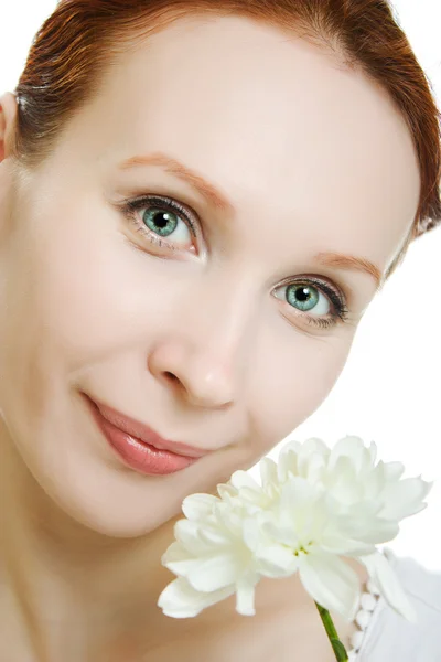 Frisk hud av unga vackra kvinnan ansikte med en blomma i hennes hår på en vit bakgrund. — Stockfoto
