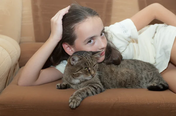 Dívka s kočkou na pohovce — Stock fotografie