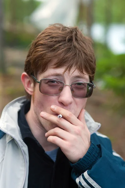Курящий человек со скептическим взглядом — стоковое фото