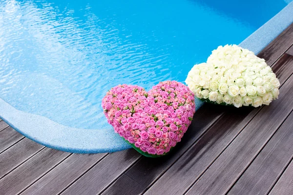 Corazones de flores cerca de piscina de natación — Foto de Stock