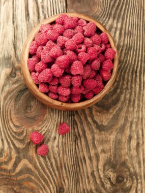 Raspberry on wood background selective focus clipart