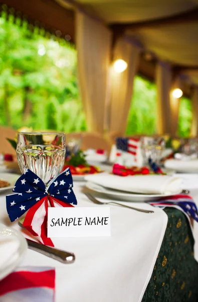 Tarjeta de invitado del evento en blanco en la mesa del restaurante con bandera americana — Foto de Stock