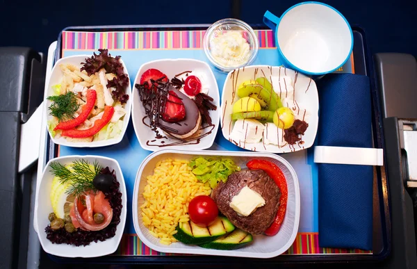 Dienblad met eten in het vliegtuig, business class reizen — Stockfoto