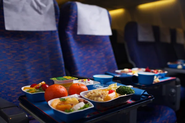 Dienblad met voedsel in het vliegtuig — Stockfoto