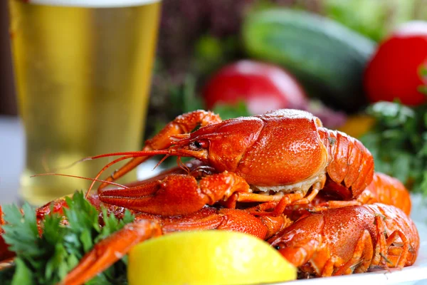 Heap of boiled crafish, glass of beer and garnish — Stock Photo, Image
