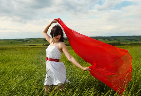 Brunette girl with red fabric in summer day — Stock Photo, Image
