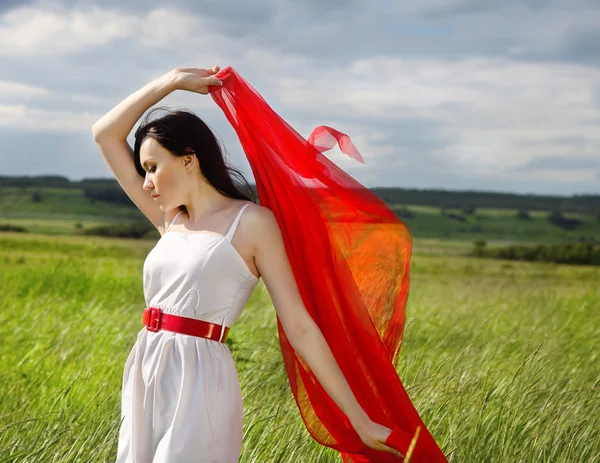 Brunette meisje met rode stof in zomerdag — Stockfoto