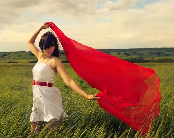 Brunette girl with red fabric in summer day — Stock Photo, Image