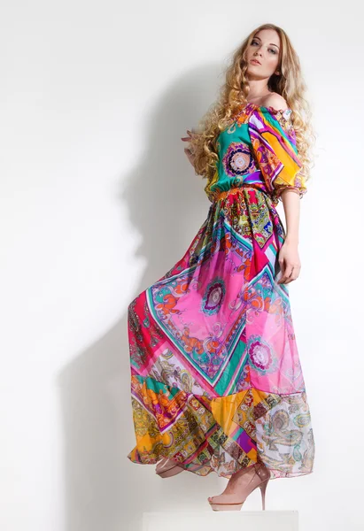 Beautiful woman in long colorful dress — Stock Photo, Image