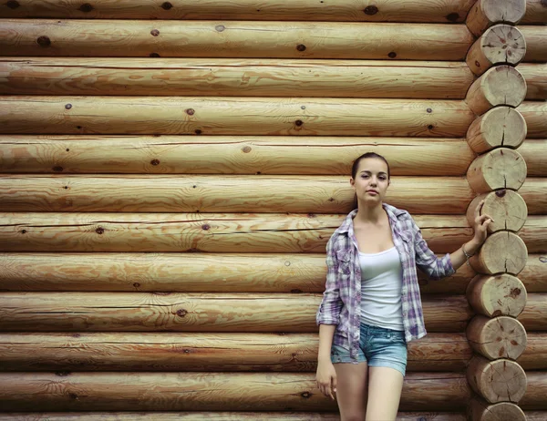 Mädchen steht in der Nähe der Holzwand — Stockfoto