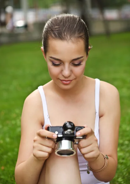Mooie lachende jong meisje met camera — Stockfoto